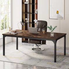 an office desk with a laptop computer on top of it in front of a bookcase