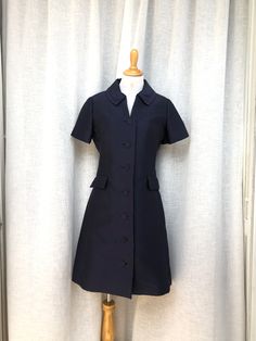 "Beautiful work button down dress by Doncaster in a navy blue color with short sleeves, two front pockets, and button down with fabric wrapped buttons. No marked size, please see measurements for proper fit.  Good vintage condition!  Measurements (flat): Shoulder to shoulder: 15.5\" Armpit to armpit : 19\" waist: 34\" Overall length: 37\"" Formal Button-up Shirt Dress With Pockets, Office Shirt Dress With Short Sleeves And Button Closure, Formal Fitted Shirt Dress With Covered Buttons, Navy Button-up Workwear Dress, Classic Button-up Business Dress, Navy Button-up Dress For Work, Classic Fitted Shirt Dress With Covered Buttons, Classic Formal Shirt Dress With Covered Buttons, Short Sleeve Shirt Dress With Buttons For Work