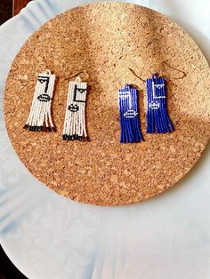 three pairs of blue and white earrings on a cork board