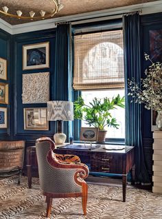 an image of a living room with blue walls and pictures on the wall above it