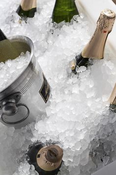 several bottles of champagne are sitting in an ice bucket filled with water and ice cubes