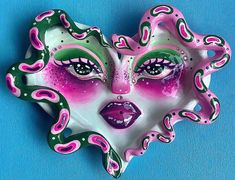 a pink and green mask on a blue background