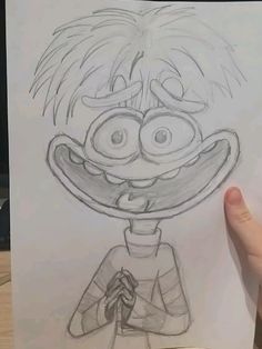 someone is holding up a drawing of an animated character