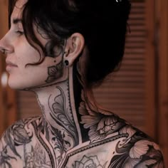 a woman with tattoos on her back and neck