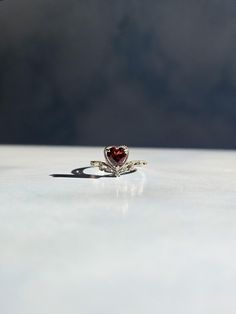 Channel your inner princess with this dainty Garnet heart adjustable ring   ONLY ONE AVAILABLE Add a royal touch to your look with this dainty garnet ring, set in gleaming S925 sterling silver. Perfect for princess core or soft girl aesthetics, the deep red gemstone adds a pop of romantic elegance, making it the perfect accessory for a fairytale-inspired wardrobe. :: Premium Quality Material :: Crafted from S925 STERLING SILVER and genuine crystals for exceptional durability and radiant shine, ensuring it will last for years.  :: Adjustable Fit :: The adjustable feature ensures a comfortable and perfect fit for almost any finger size, offering versatility and ease of wear. :: Hypoallergenic :: Gentle on the skin, this ring is ideal for sensitive skin, preventing irritation and allergic rea Red Crystal Promise Ring With Gemstone, Red Heart-shaped Birthstone Promise Ring, Elegant Red Heart Ring With Gemstone, Garnet Heart Ring, Classic Red Gemstone Crystal Ring, Princess Crown Ring, Ring Heart Shape, Crown Ring Princess, Girl Aesthetics