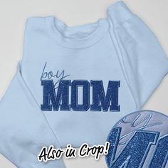 Get ready to sparkle and show off your "boy mama" pride with our Mom Shirt Glitter! This fun and stylish t-shirt features sparkly glitter accents and a bold "boy mom" statement, making it the perfect addition to your wardrobe. Show the world your love for your little boy with this playful and trendy shirt! 8 oz./yd² (US) 13.3 oz./L yd (CA), 50/50 cotton/polyester, 20 singles Classic Fit Air jet yarn for softer feel and reduced pilling Double-needle stitching at shoulders, armholes, neck, waistba Blue Crew Neck Tops With Glitter Print, Blue Glitter Print Crew Neck Tops, Boy Mom Sweatshirt, Valentines For Mom, Brides Babes, Boy Mama, Bridal Shower Welcome Sign, Columbia Blue, Mom Sweatshirt