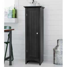 a tall black cabinet sitting next to a table