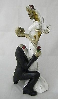 a figurine of a man kneeling next to a woman holding a flower in her hand