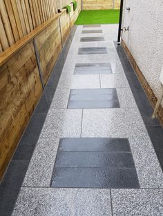 an empty walkway in front of a wooden fence