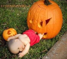 a baby laying on its back next to a pumpkin