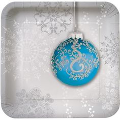 a blue ornament hanging from a string on a white tray with snowflakes