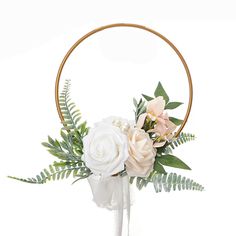 a white flower arrangement in a vase with greenery and an oval wooden ring around it