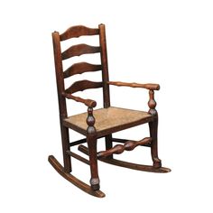 a wooden rocking chair with roped seat and arm rests on an isolated white background