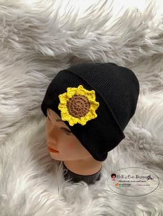 a mannequin head wearing a black hat with a sunflower on it