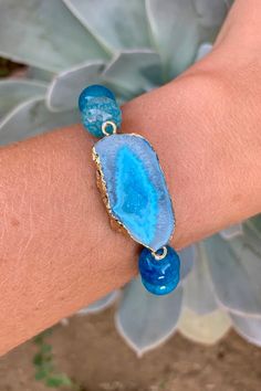 "Stunning bracelet with beautiful 10mm aqua blue Dragon's Vein Agate Beads and a matching gold plated Druzy Agate Geode Slice Pendant. The pendant is 0.5 inches long and 1.25 inches wide. The bracelet is elastic with a length of 7\" unstretched. Item will be shipped 1 - 2 business days after purchase. \"Dragon's Veins Agate can heighten creative visualization. It strengthens the ability and will to manifest one's life purpose on the earth planet. Promotes energy and strength, and will help one d Blue Agate Beaded Bracelets For Gift, Blue Beaded Agate Bracelets, Blue Agate Geodes, Blue Agate Geodes With Natural Stones, Bohemian Blue Agate Bracelets, Blue Agate Round Beads Crystal Bracelet, Blue Agate Bracelet As Gift, Adjustable Blue Crystal Bracelet With Gemstone, Handmade Blue Agate Bracelets