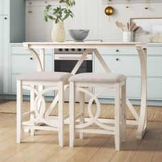 a kitchen table with two stools next to it