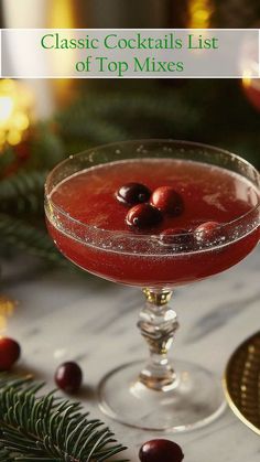 a glass filled with red liquid and garnished with cherries on the rim