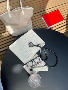 a pair of glasses, a book and a stethoscope on a table