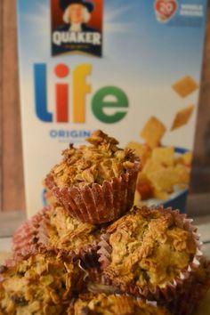 three muffins sitting on top of a table next to a box of life cereal