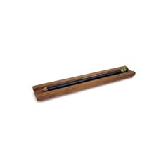 a wooden pen holder with a black pencil in it