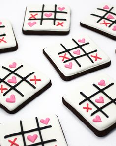 decorated cookies arranged in the shape of ticquets with hearts and crosses on them