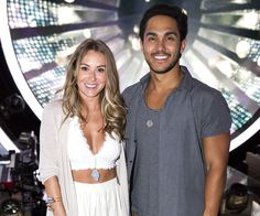 a man and woman standing next to each other in front of a wheel of fortune