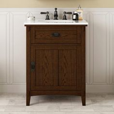 a bathroom vanity with two faucets and a mirror on the wall above it