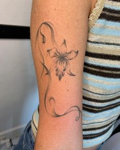 a woman's arm with a tattoo on it that has a flower in the middle