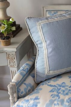 a blue and white chair sitting next to a table with a potted plant on it