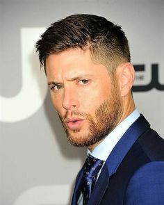 a close up of a person wearing a suit and tie with a serious look on his face