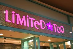 the entrance to a store with pink lettering on it