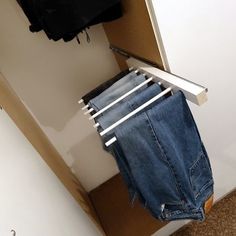 a pair of blue jeans hanging on a clothes line next to a white closet door