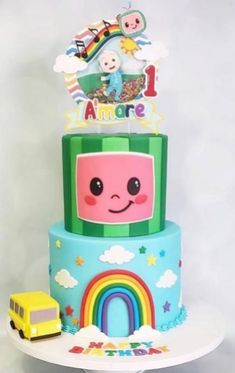 a multi layer cake decorated with an image of a bus and rainbows on top