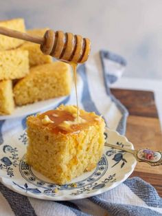 a piece of cake on a plate with honey being drizzled over it