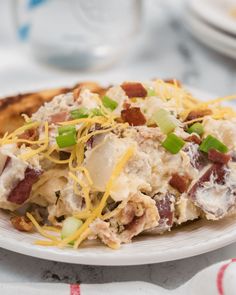 a close up of a plate of food with meat and cheese on it next to bread