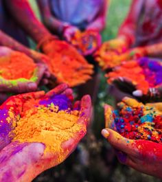 many hands are covered in colorful powder