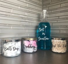 four jars with labels on them sitting on a counter