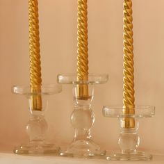 three glass candlesticks sitting next to each other