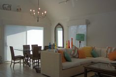 a living room filled with lots of furniture and a chandelier hanging from the ceiling