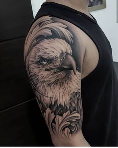 an eagle tattoo on the arm and shoulder is shown in black and grey colors, with white