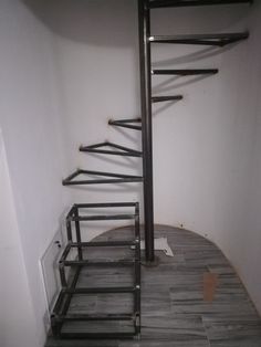 a spiral staircase in an empty room with tile flooring