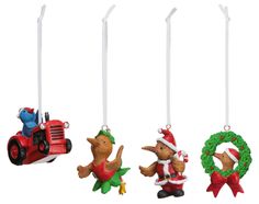 three ornaments in the shape of animals and a tractor are hanging from strings on a white background