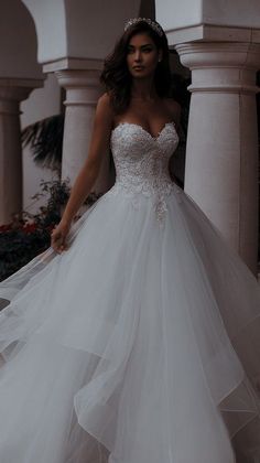 a woman in a wedding dress is standing outside