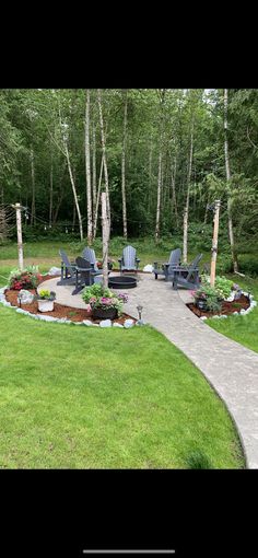 an outdoor patio with chairs and flowers in the center, surrounded by green lawning