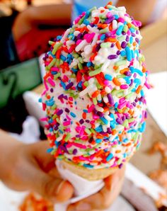 an ice cream cone filled with sprinkles on top of a table