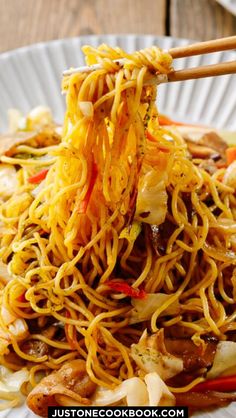 a plate with noodles and chopsticks on it