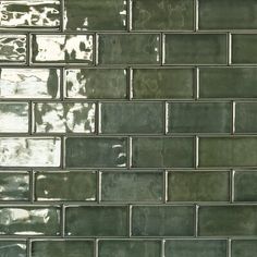 a close up view of a green glass tile backsplash with white grouting