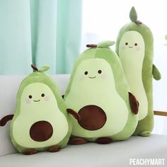 three peas stuffed animals sitting on top of a couch