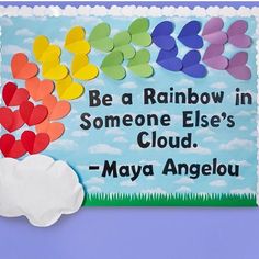 a paper sign that says, be a rainbow in someone else's cloud - mayo angelou