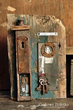 an old wooden box with keys attached to it and a doll in the front door